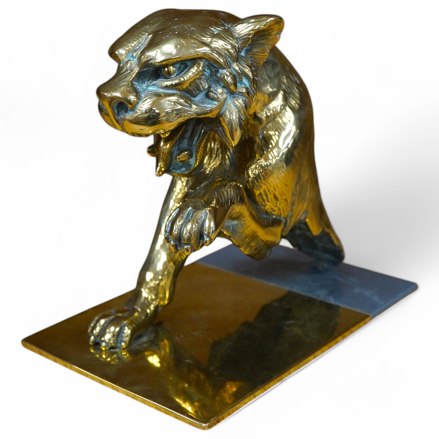 A substantial brass car mascot of the front half of a big cat roaring, mounted on a sheet of brass, 15cm high. Condition - good.